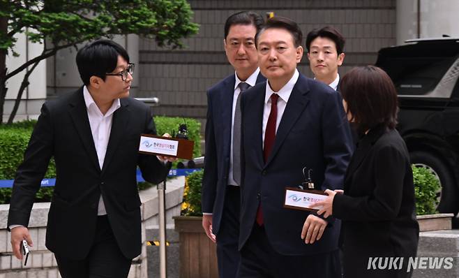 윤석열 전 대통령이 19일 오전 서울 서초구 중앙지방법원에서 열린 내란 우두머리 혐의, 직권남용 권리행사방해 혐의 사건 4차 공판에 출석해 취재진의 질문을 받으며 이동하고 있다. 사진공동취재단
