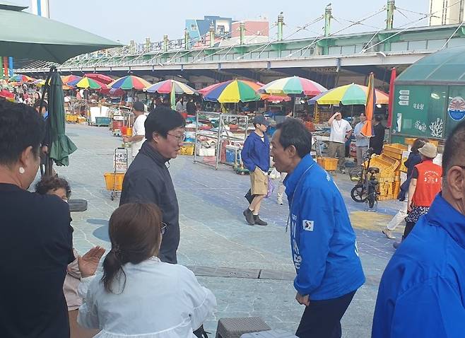 우상호 전 의원이 지난 17일 강원도 동해 묵호항을 찾아 주민들과 인사하고 있다. 우상호 전 의원 페이스북 캡처