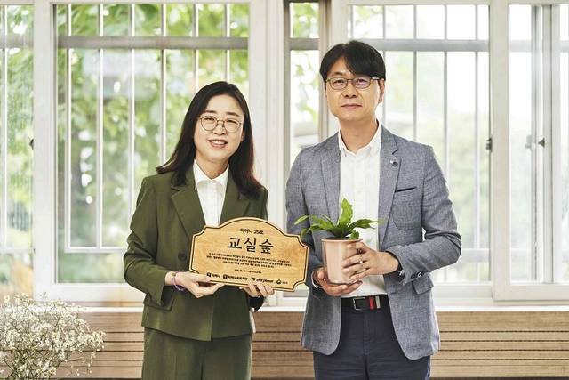 김영주(오른쪽) 상무가 서울 서이초등학교와 ‘티머니와 함께하는 교실 숲 조성 캠페인’ 현판 전달식을 진행하고 있다.티머니 제공