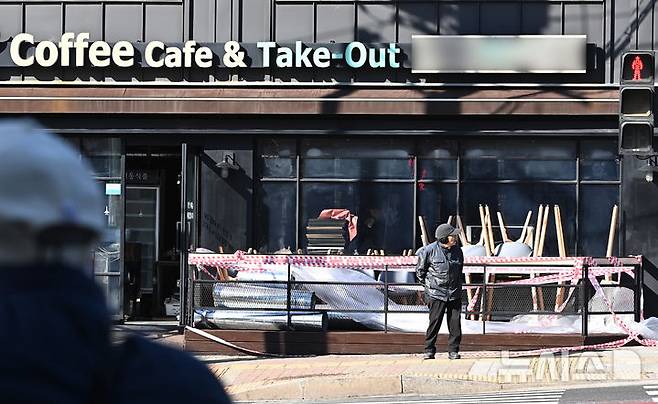 [수원=뉴시스] 김종택 기자 = 경기도 수원시 한 폐업한 카페 매장 앞에 테이블과 의자 등이 쌓여 있다. 2025.02.17. jtk@newsis.com