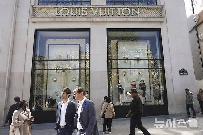 [파리=AP/뉴시스] 25일(현지 시간) 월스트리트저널에 따르면 유럽 명품 업계는 '명품 브랜드의 미국 생산'은 말이 안 되는 일이라고 했지만, 트럼프발 관세 정책은 이를 압박하고 있다. 사진은  파리에서 사람들이 루이비통 플래그십 스토어 앞을 지나가고 있는 모습. 2025.05.26.
