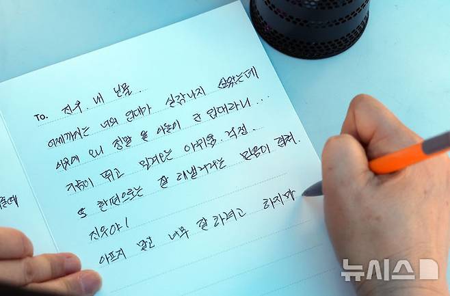 [논산=뉴시스] 김명년 기자 = 26일 오후 충남 논산 육군훈련소에서 열린 현역병 입영 행사에서 한 입영장정의 어머니가 편지를 적고 있다. 2025.05.26. kmn@newsis.com