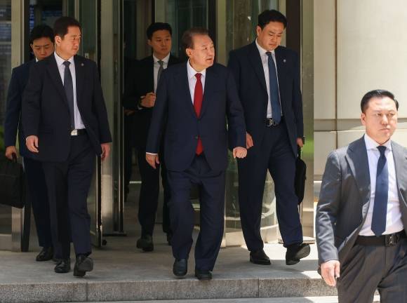 윤석열 전 대통령이 26일 서울 서초구 서울중앙지방법원에서 열린 내란 우두머리 혐의·직권남용 권리행사 방해 혐의 사건 5차 오전 공판을 마친 후 지지자들을 바라보며 차량으로 향하고 있다. 2025.5.26 사진공동취재단