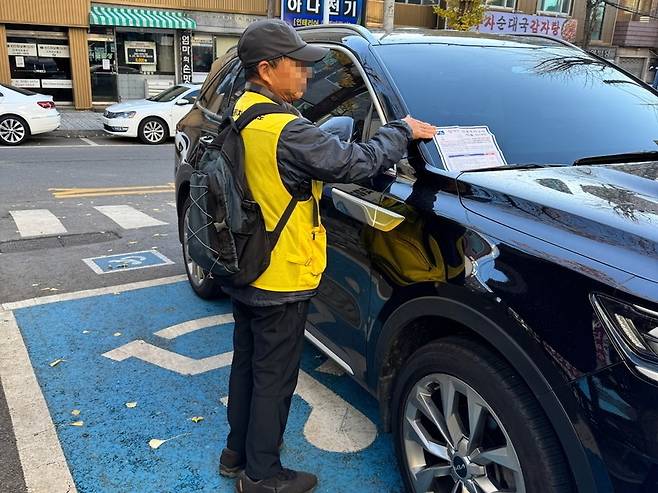 ▲ 복지 일자리에서 장애인 전용 주차구역 위반 행위를 단속 중인 참여자. /사진제공=인천시