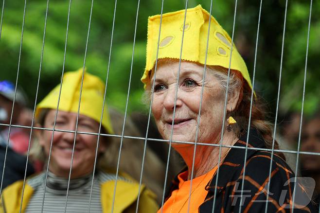 26일(현지시간) 영국 브록웍스의 쿠퍼스 힐에서 열린 '구르는 치즈 잡기' 대회에서 관람객들이 치즈 모자를 쓰고 있다. ⓒ 로이터=뉴스1