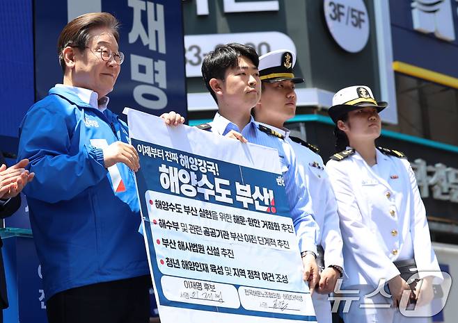 이재명 더불어민주당 대통령 후보가 민주당 험지로 꼽히는 부산·경남(PK) 지역 유세에 나선 14일 부산 부산진구 서면을 찾아 권기흥 에이치라인해운해상직원노조 위원장과 해양수도 부산 협약서에 서명한 뒤 기념촬영을 하고 있다.(공동취재) 2025.5.14/뉴스1 ⓒ News1 안은나 기자