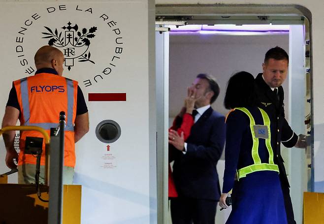 에마뉘엘 마크롱 프랑스 대통령이  25일 베트남 하노이의 노이바이 국제공항에 도착해 내리기 전 부인 브리지트 마크롱이 에마뉘엘 마크롱의 얼굴을 밀치고 있다./로이터 연합뉴스