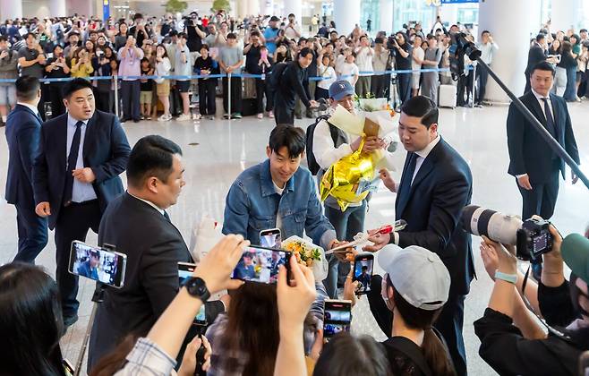 손흥민이 팬에게 꽃다발과 선물 등을 전달받고 있다. / 뉴시스
