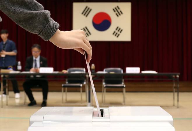 제21대 대통령 선거 재외투표 첫날인 20일 일본 도쿄 미나토구 주일한국대사관에 마련된 재외투표소에서 유권자가 투표함에 투표용지를 넣고 있다. 연합뉴스