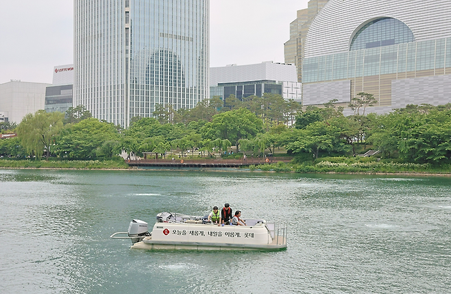 롯데와 송파구청, 젠스, 녹색미래 관계자들이 석촌호수 수질 개선 작업을 진행하고 있다.