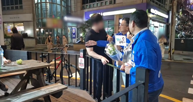 23일 박주민 더불어민주당 의원 유튜브 채널에 올라온 영상의 한 장면. 이날 박 의원은 부산 광안리 일대에서 이재명 민주당 대선 후보를 위한 선거 유세를 하고 있었는데, 검은색 상의를 입은 한 남성(맨 왼쪽)이 박 의원(왼쪽 세 번째)에게 다가가 대화를 시도하고 있다. '박주민TV' 유튜브 영상 캡처