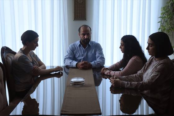 영화 '신성한 나무의 씨앗' 속 주무대는 집 안 공간이다. 식탁에 앉아 있는 구도만으로도 집 안의 권위와 친밀도를 엿볼 수 있다. 왼쪽부터 엄마 나즈메, 아빠 이만, 둘째 딸 사나, 첫째 딸 레즈반. 사진 그린나래미디어