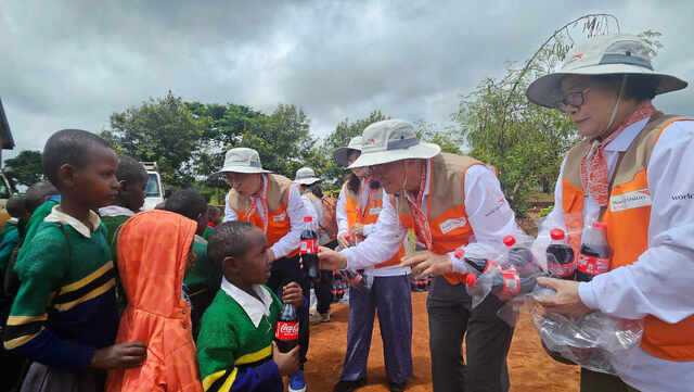 탄자니아 세렝게티 인근 시골 마을 은다바시 초등학교에서 최근 이 학교 어린이들이 나란히 줄을 서서 이건영(가운데) 인천제2교회 원로목사와 노원석(왼쪽) 담임목사가 나눠주는 콜라를 받으며 즐거워하고 있다.