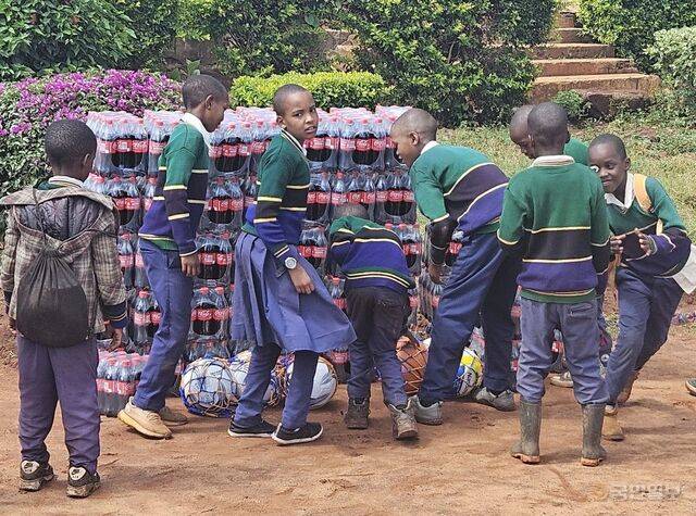탄자니아 은다바시 초등학교 아이들이 선물로 받을 콜라를 보며 즐거워하고 있다.