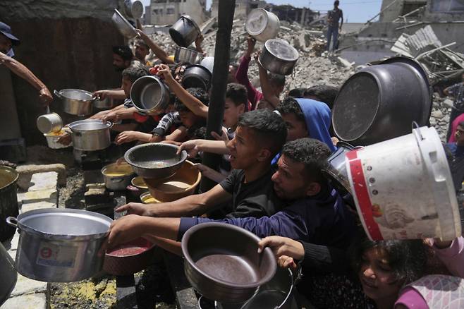 19일(현지 시간) 가자지구 북부 자발리아의 급식소에 구호 음식을 받으려는 팔레스타인 주민들이 몰려들고 있다. 이스라엘은 지난 10주간 가자지구 내 구호물자 반입을 전면 차단해 왔던 봉쇄를 완화하고 기본 식량 반입을 허용하기로 했다. /AP=뉴시스