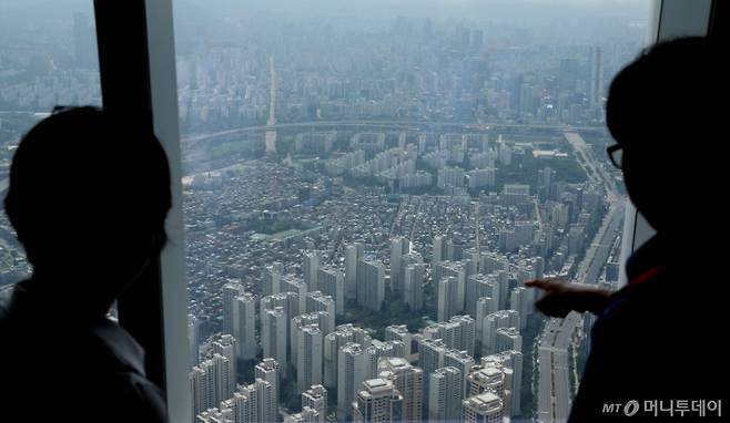 [서울=뉴시스] 조수정 기자 = 26일 서울 송파구 롯데월드타워 전망대 서울스카이에서 시민들이 서울 강남, 송파구 아파트를 바라보고 있다.   서울 주택 매매가격은 0.5% 상승해 12개월째 오름세다. 유형별로 아파트 0.61%, 단독주택 0.47%, 연립주택 0.25% 순으로 상승률이 높았다. 아파트값 상승으로 서울 전체 주택 매매가격도 상승세가 지속되고 있다. 이달 전국 아파트 평균 매매가격은 5억2543만원, 서울 아파트 평균 매매가격은 13억4543만원으로 집계됐다. 서울 아파트 평균 매매가격은 지난달(13억2965만원) 2008년 12월 통계 발표 이후 처음으로 13억원을 돌파했다. 아파트 평균 매매가격이 오르면서 서울 주택 평균 매매가격도 사상 최초로 10억원을 넘어 10억398만원을 기록했다. 2025.05.26. chocrystal@newsis.com /사진=조수정