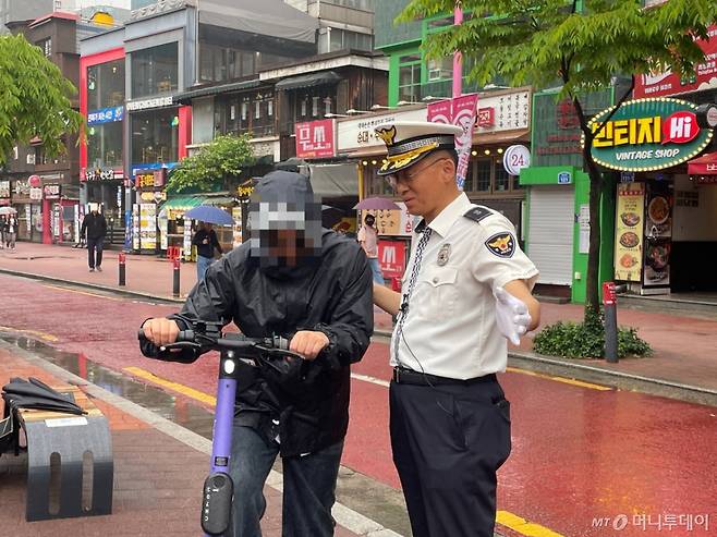 지난 16일 오후 서울 마포구 홍대입구역 인근 '레드로드'에서 서울 마포경찰서 관계자가 '킥보드 없는 거리' 계도 캠페인을 벌이고 있다. /사진=이지현 기자.