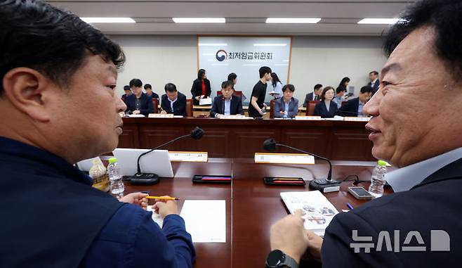 [세종=뉴시스] 강종민 기자 = 지난 4월 22일 세종시 정부세종청사에서 열린 최저임금위원회 제1차 전원회의에서 류기정 사용자 위원(오른쪽)과 류기섭 근로자 위원이 대화하며 미소 짓고 있다. 2025.04.22. ppkjm@newsis.com