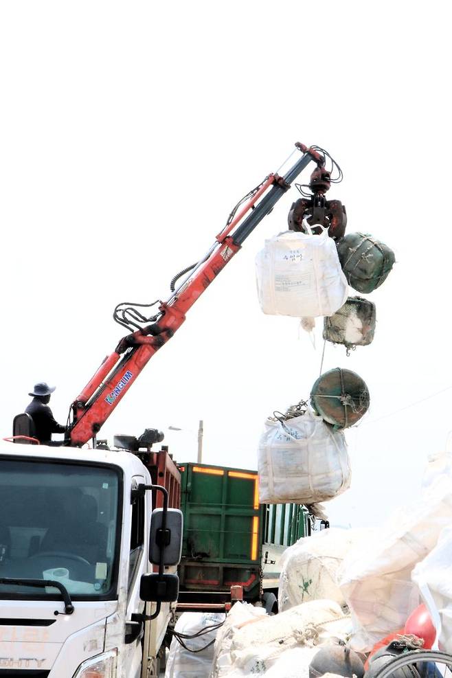 [서천=뉴시스] 서천군 유부도에서 작업자가 모아진 해양쓰레기들을 배로 운반하기 앞서 트럭에 싣고 있다.   *재판매 및 DB 금지