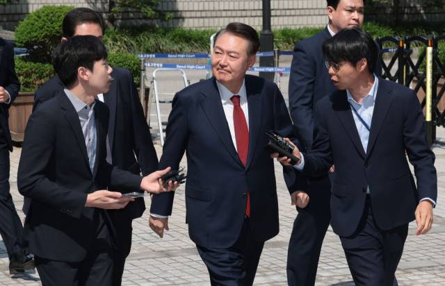 ▲윤석열 전 대통령이 5월 26일 서울 서초구 서울중앙지방법원에서 열린 내란 우두머리 혐의·직권남용 권리행사 방해 혐의 사건 5차 공판에 출석하며 지지자들을 바라보고 있다. ⓒ연합뉴스