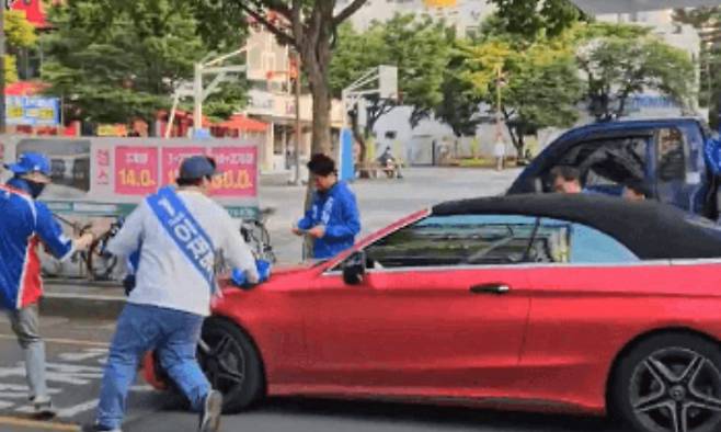 20대 A씨가 차량 경적을 울리며 선거운동을 방해하자 선거운동원들이 이에 항의하며 A씨를 제지하고 있다. 민주당 동영상 캡쳐