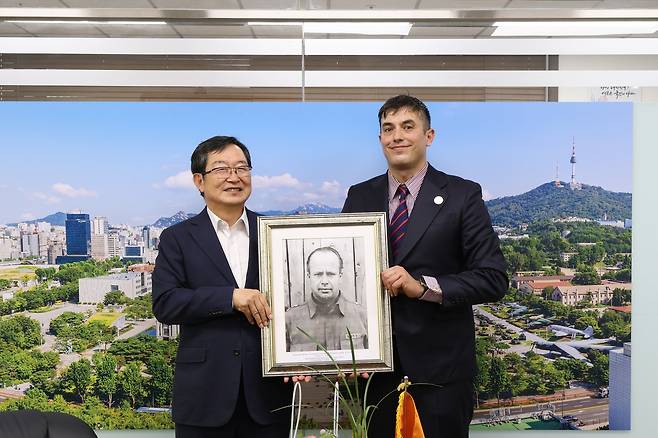 백승주 전쟁기념사업회장과 빅토르 야부스 씨가 기증 사진과 함께 기념사진을 찍고 있다.(전쟁기념사업회 제공)