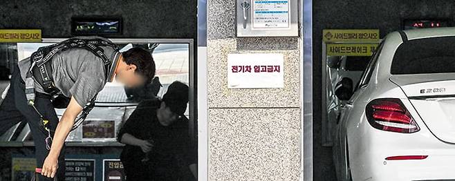 전기차는 들어오지 마세요 - 27일 서울 강남구의 한 주차타워 입구에 ‘전기차 입고금지’ 스티커가 붙어 있다. 최근 전기차 화재 사고가 잇따르면서 전기차 주차를 금지하는 주차장이 늘어나고 있다. /고운호 기자
