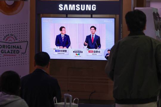 제21대 대통령선거 후보 정치분야 TV토론회가 열린 27일 서울역 대합실에서 시민들이 토론회 중계방송을 지켜보고 있다. [연합뉴스]