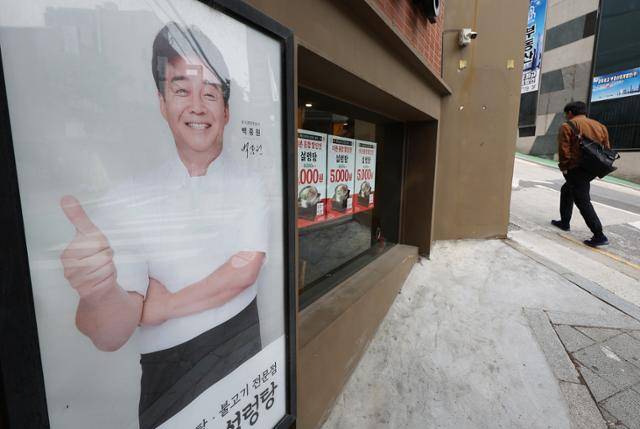 백종원 더본코리아 대표가 지난 9일 300억원 규모의 가맹점 상생 지원책을 발표했다. 더본코리아는 13일부터 오는 24일까지 본사가 전액 부담하는 할인 행사를 진행한다. 사진은 13일 서울 시내 한 더본코리아 인생설렁탕 매장에 할인 안내문과 백 대표 사진이 붙어 있다. 연합뉴스