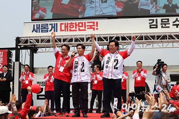 김문수 국민의힘 대통령 후보가 28일 경남 김해 유세에서 박상웅 국회의원(오른쪽), 조해진 전 국회의원(왼쪽)과 대선 승리를 위해 파이팅 하고 있다. [사진=임승제 기자]