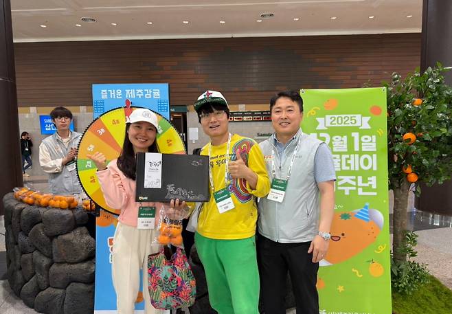 “뭐라도 나오면 기분 좋잖아.” 감귤 앞에선 다들 웃는다. 누구는 카라향, 누구는 감귤 박스. 대단한 경품 아니어도 사람들은 기분 좋게 사진을 찍었다. 감귤이 이렇게까지 분위기를 바꿔놓을 줄, 누가 알았을까. (제주농협 제공)