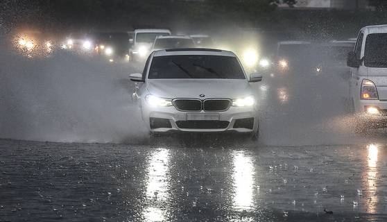 28일 오후 대구 수성구 만촌동 화랑교에서 퇴근길에 오른 차들이 쏟아지는 장대비로 인해 만들어진 웅덩이 속에 서행하고 있다. 이날 오후 퇴근 시간대에 대구와 경북에 비를 동반한 우박이 쏟아졌으며, 동구 신암동에서는 지름 1.8㎝의 우박이 관측되기도 했다. 연합뉴스