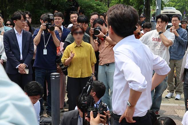 이준석 개혁신당 대선후보가 28일 서울 여의도공원에서 유세를 마치고 백브리핑을 하던 중 한 시민으로부터 전날 TV토론회에서 여성 신체에 대한 폭력적 표현을 언급한 것과 관련해 항의받고 있다. [사진 출처 = 연합뉴스]