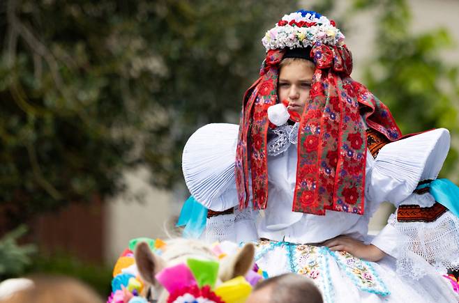 동유럽 낭만을 품은 나라 체코에서 전통 민속축제 '왕들의 탈 것'이 진행됐다. 사진은 지난 25일(현지시각) 체코 블츠노프에서 진행된 전통 민속 축제 '왕들의 탈것'에서 올해 '왕'으로 뽑힌 한 소년이 전통 여성 의상을 입고 입에는 꽃장식을 물은 뒤 말 위에 오른 모습. /사진=로이터