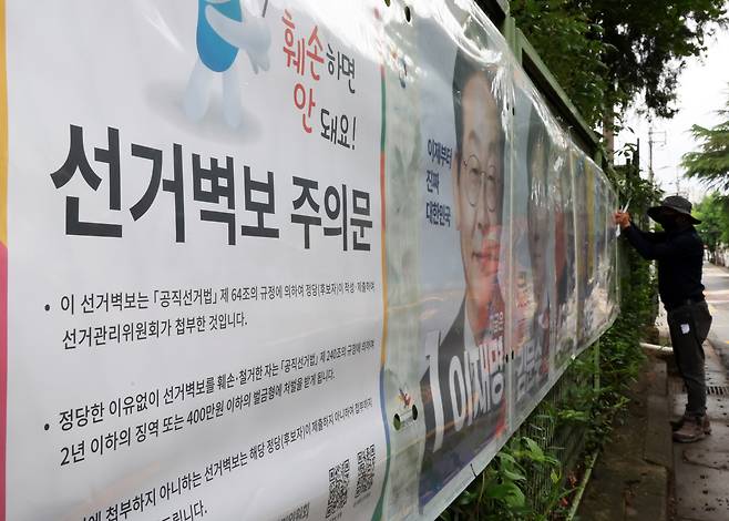 제21대 대통령 선거 벽보 부착을 시작한 지난 15일 전북선거관리위원회 관계자가 전주시 완산구 효자동의 한 아파트 입구에 후보자 벽보를 붙이고 있다. [연합]
