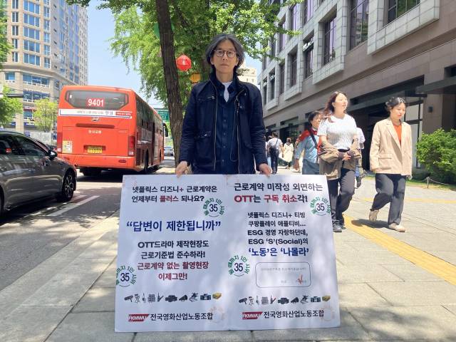 ▲이상길 전국영화산업노조 사무국장이 지난 5월 8일 서울 넷플릭스 입주 건물 앞에서 OTT드라마 제작 현장의 근로기준법 준수를 촉구하는 1인시위를 진행했다. ⓒ프레시안(손가영)