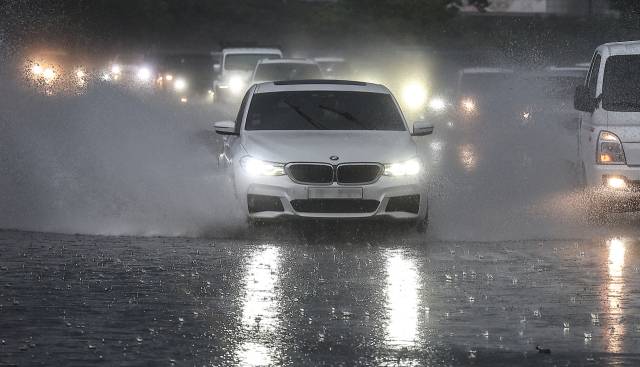 28일 오후 대구 수성구 만촌동 화랑교에서 퇴근길에 오른 차들이 쏟아지는 장대비로 인해 만들어진 웅덩이 속에 서행하고 있다. 이날 오후 퇴근 시간대에 대구와 경북에 비를 동반한 우박이 쏟아졌으며, 동구 신암동에서는 지름 1.8㎝의 우박이 관측되기도 했다. 연합뉴스