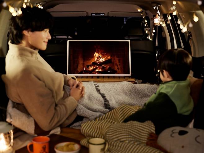 LG전자 모델이 차에서 LG 스탠바이미 2를 보는 모습.