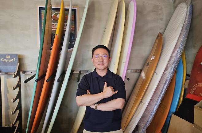 신성재 서프홀릭 대표가 28일 본지와 인터뷰 후 서프홀릭 부산 송정1호점의 서프보드 앞에서 포즈를 취하고 있다. 사진=변옥환 기자
