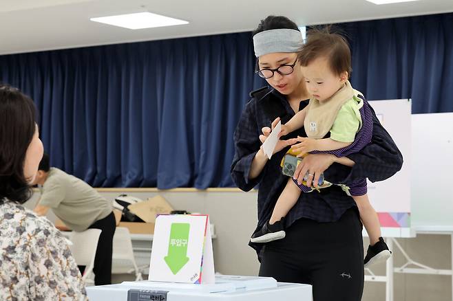 제21대 대통령선거 사전투표 첫날인 29일 오전 경기 화성시 동탄9동 행정복지센터 3층 대강당에 마련된 사전투표소에서 한 유권자가 아이와 함께 투표함에 투표용지를 넣고 있다. 김영원 기자 forever@hani.co.kr