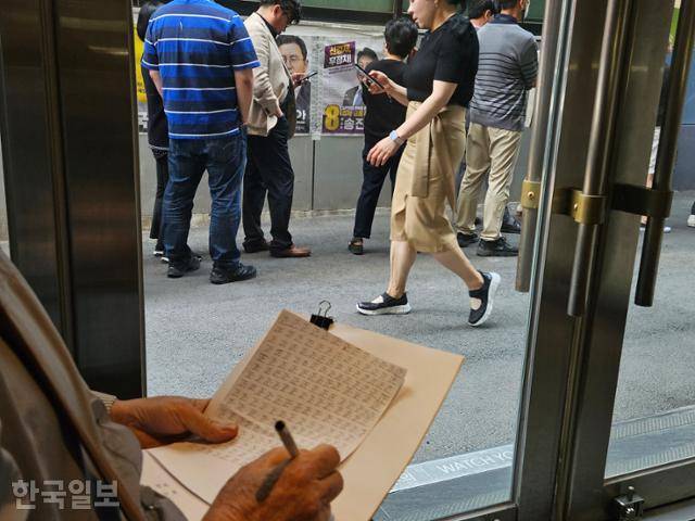 29일 서울 중구의 한 투표소에서 김모씨가 "부정선거인지 감시한다"며 투표장을 찾은 시민들의 수를 일일이 세어 흰 종이에 '바를 정'자를 쓰고 있다. 이유진 기자