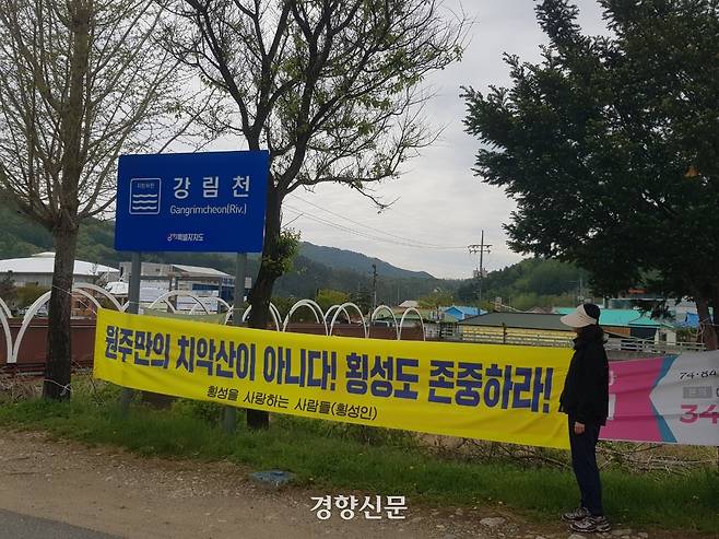 지난 25일 오전 강원 횡성군 강림면의 한 주민이 강림천 변에 설치된 현수막을 살펴보고 있다. 현수막엔 ‘원주만의 치악산이 아니다! 횡성도 존중하라’라는 글이 적혀있다. 최승현 기자