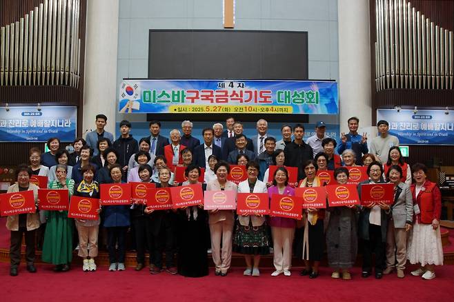 미스바구국기도운동본부는 27일 부산 순복음금정교회에서 제4차 미스바구국금식기도대성회를 개최했다. 박영은(앞줄 오른쪽 여덟 번째) 미스바구국기도운동본부 대표와 참석자들이 성회 피켓을 들고 단체 촬영을 하고 있다.