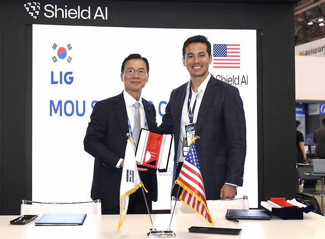 29일 부산 벡스코에서 열린 '국제해양방위산업전(MADEX) 2025'에서 신익현 LIG넥스원 대표이사(왼쪽)와 브랜던 쳉 실드AI 최고경영자(CEO)가 '미래 전장에 특화된 공동 솔루션 개발을 위한 포괄적 업무협약'을 체결한 후 기념촬영을 하고 있다. LIG넥스원