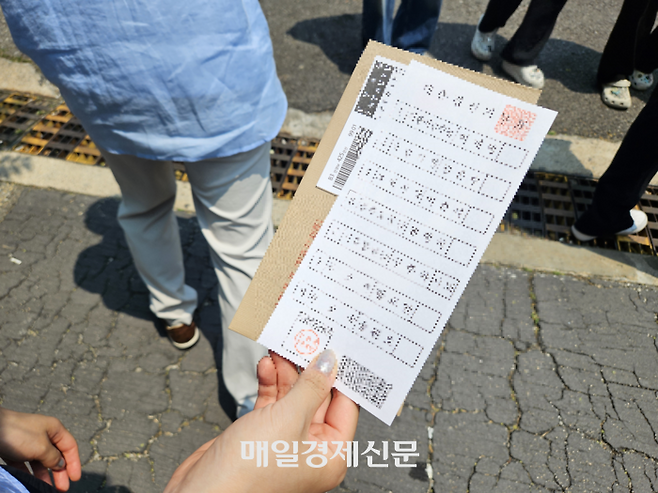 29일 오전 11시 25분께 구신촌동주민센터 사전투표소에서 한 유권자가 배부받은 투표용지를 들고 투표소에 줄을 서 있다. [지혜진 기자]