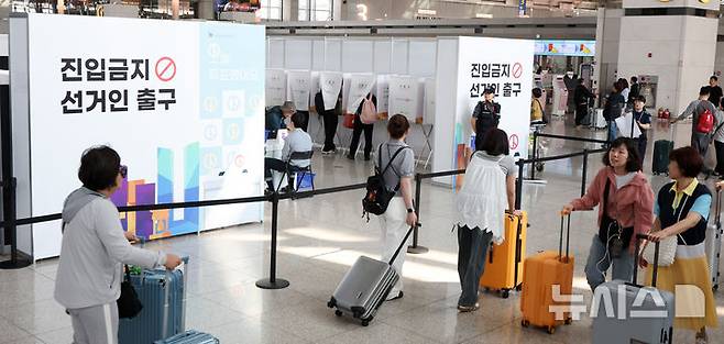 [인천공항=뉴시스] 김선웅 기자 = 제21대 대통령 선거 사전투표 첫날인 29일 인천국제공항 제1여객터미널 G체크인카운터 앞에 설치된 인천공항 사전투표소에서 여행을 앞둔 유권자들이 사전투표를 하고 있다. 2025.05.29. mangusta@newsis.com