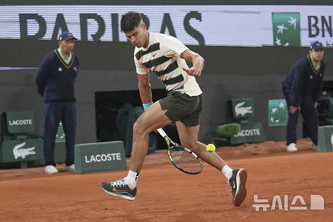 [파리=AP/뉴시스] 카를로스 알카라스(2위·스페인)가 28일(현지 시간) 프랑스 파리 롤랑가로스에서 열린 프랑스오픈 남자 단식 2회전에서 파비안 마로잔(56위·헝가리)을 상대로 트위너샷을 구사하고 있다. 2연패를 노리는 알카라스가 3-1(6-1 4-6 6-1 6-2)로 이기고 3회전에 올랐다. 2025.05.29.