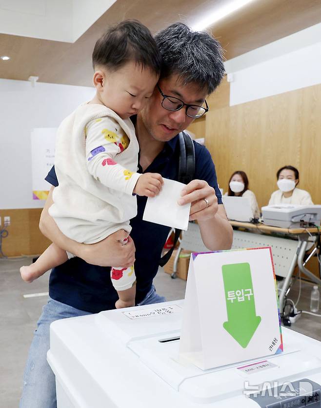 [서울=뉴시스] 김진아 기자 =제21대 대통령선거 사전투표가 시간된 29일 서울 중구 중림동주민센터에 마련된 사전투표소에서 아빠와 아이가 투표를 하고 있다. 2025.05.29. bluesoda@newsis.com