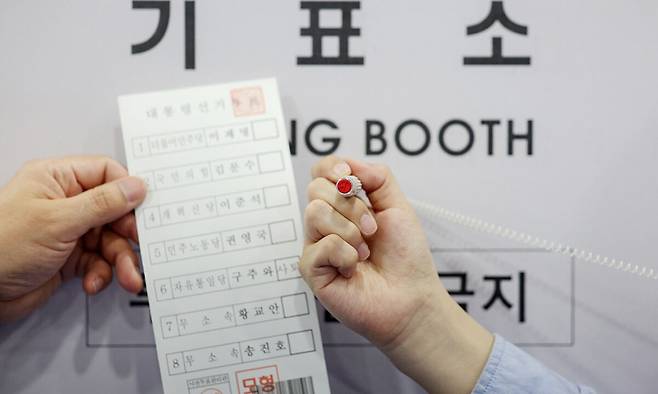 제21대 대통령선거 사전투표를 하루 앞둔 28일&nbsp;서울 관악구 신사동복합청사에 마련된 제21대 대통령선거 사전투표소에서 서울시선관위 관계자가 투표용지와 기표도장을 들어보이고 있다. 뉴시스