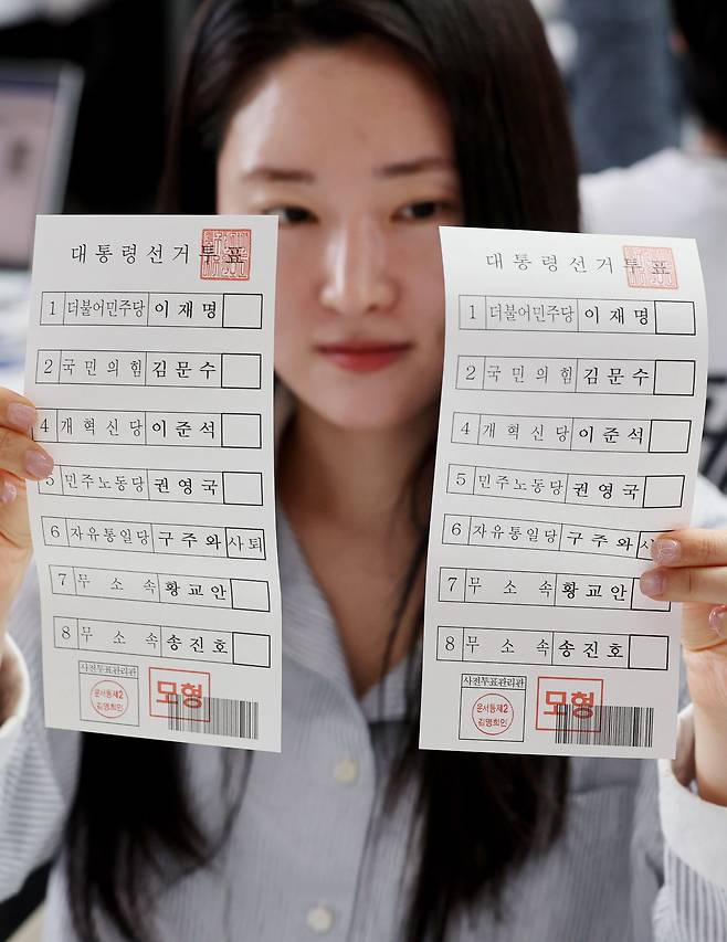 투표 용지를 보여주는 선관위 관계자